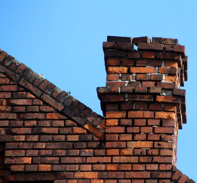 Damaged chimney on an Leonard home showing cracks and missing mortar